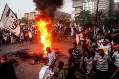 Manifestantes sudaneses corean consignas junto a neumáticos ardiendo durante una manifestación en la capital, este martes en Jartum, Sudán.