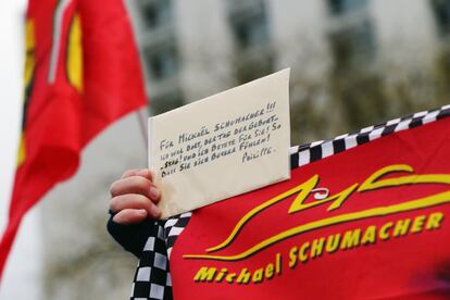 Un seguidor de Schumacher sujeta una cartulina con mensajes de ánimo para el piloto alemán