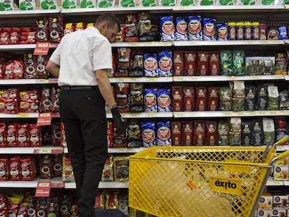 Un hombre acomoda diversas marcas de café en un supermercado en Bogotá (Colombia), en 2017.