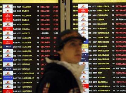 Un pasajero ante un panel que muestra decenas de vuelos retrasados, ayer en la T-4 de Barajas.
