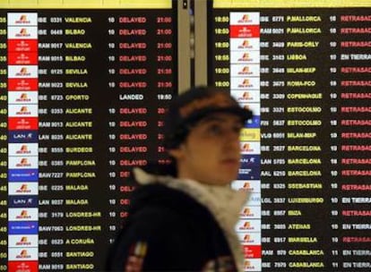 Un pasajero ante un panel que muestra decenas de vuelos retrasados, ayer en la T-4 de Barajas.