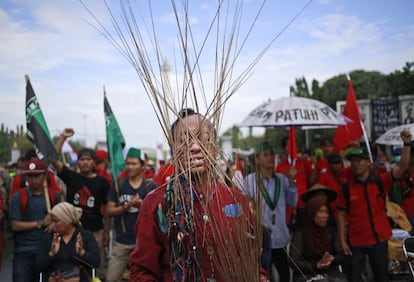 Un activista porta alrededor de su cabeza varias piezas de madera durante una manifestación en el exterior del palacio presidencia,l en Yakarta, Indonesia.