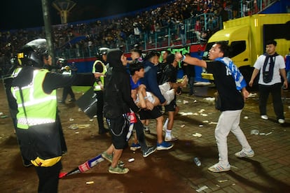 Aficionados evacúan a un hombre por los gases lacrimógenos lanzados por la policía. “Este es un día oscuro para todos los implicados en el fútbol y una tragedia incomprensible”, ha lamentado Gianni Infantino, presidente de la FIFA, en un comunicado emitido este domingo.