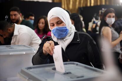 Una ciudadana siria deposita su voto este domingo durante los comicios legislativos en un colegio electoral de Damasco.
