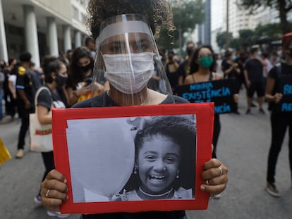 Mulher empunha foto de Ágatha, morta aos 8 anos durante uma ação policial no Rio de Janeiro em 2019.