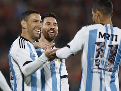 Lionel Messi (c) y Ángel di María (d) acompañan a Maxi Rodríguez (i), en su partido de despedida en Rosario (Argentina).