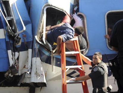Los rescatistas intentan sacar a un pasajero atrapado.