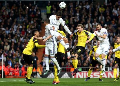 El defensa alemán del Borussia Dortmund Marcel Schmelze (dcha) y el delantero francés del Real Madrid Karim Benzema, saltan por un balón.