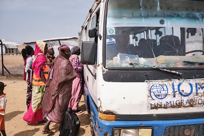 Mujeres sudanesas y sursudanesas que huyen de la guerra en Sudán acaban de llegar a Wunthou, tierra segura pero incierta en Sudán del Sur, donde un camión y pequeños autobuses de la OIM las esperan para poder seguir su ruta migratoria, el 12 de febrero de 2025. Los picos de entradas fluctúan en función del conflicto en Sudán. Por ejemplo, las ofensivas en diciembre, correspondientes a los movimientos en el frente con el avance del Ejército sudanés que empuja a los rebeldes hacia el oeste, provocaron la entrada de más de 5.000 personas al día en Sudán del Sur, tanto por pasos fronterizos oficiales cómo informales, según datos de la ONG Médicos Sin Fronteras, que trabaja en la zona. En febrero hubo picos de 2.000 a 2.800 y, desde marzo, la tendencia está a la baja pero con picos de 1.400 al día.