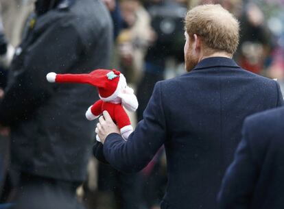 El príncipe Harry lleva un juguete de peluche después de asistir al servicio religioso del día de Navidad en la iglesia de Sandringham.
