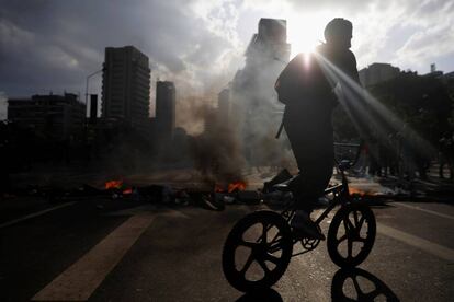 Un joven conduce su bicicleta cerca de una barricada durante una protesta en la ciudad de Caracas (Venezuela), el 8 de abril de 2017.