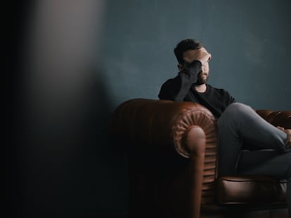 Un hombre se lamenta en un sillón.