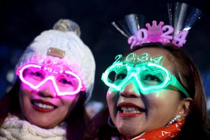 Dos mujeres lucen sus gafas 2024 durante las celebraciones de fuegos artificiales y Nochevieja en el río Támesis en Londres, Gran Bretaña.