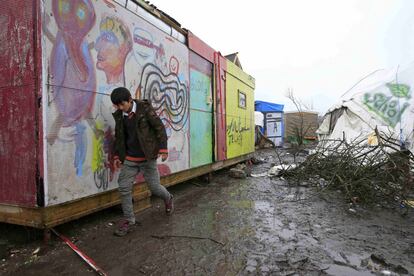 A young migrant from Afghanistan walks in the mud in the south part of a camp for migrants called the "jungle", during a rainy winter day in Calais, northern France, February 22, 2016. French authorities have asked migrants living in tents and makeshift shelters in the southern sector of the "jungle", to leave the area.  REUTERS/Pascal Rossignol   