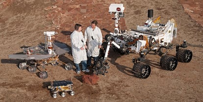 Dos ingenieros, junto a modelos de 'Sojourner' (en el frente),  'Spirit' y 'Opportunity' (izquierda) y 'Curiosity' (derecha).