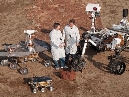 Dos ingenieros, junto a modelos de 'Sojourner' (en el frente),  'Spirit' y 'Opportunity' (izquierda) y 'Curiosity' (derecha).