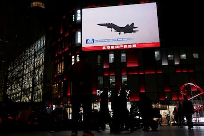 Imagen de un avión de combate chino en una pantalla situada junto a un centro comercial de Pekín, este martes.