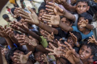 Jóvenes musulmanes de la etnia rohingya tratan de conseguir chocolates y leche que un hombre reparte en el campo de refugiados de Taiy Khali (Bangladés).