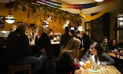 Varias personas toman algo en el interior de una cervecería en el centro de Bolzano.