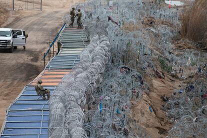 Texas National Guard officers monitor the river in Eagle Pass, Texas