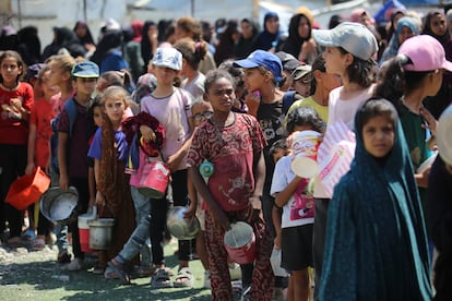 Una grupo de niños hace cola para recibir comida en el campo de refugiados de Nuseirat, este viernes. 