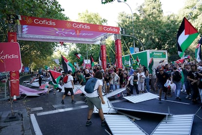 Manifestantes propalestinos tiran las vallas se seguridad al suelo, durante la última etapa de la Vuelta. 