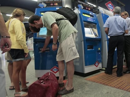 Viajeros de metro compran billetes en una estación de Madrid.