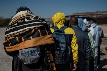 Migrantes venezolanos hacen fila para recibir alimentos bajo el Puente Internacional Paso del Norte.