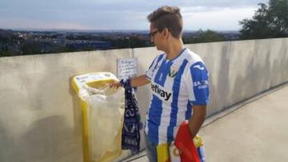 Un aficionado del CD Leganés deposita un vaso de plástico en la papelera.