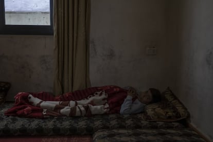 Ahmed tiene 11 años, está acostado en el salón de su casa tras sufrir un apuñalamiento al rebuscar comida entre la basura por la noche para conseguir comida para su familia.