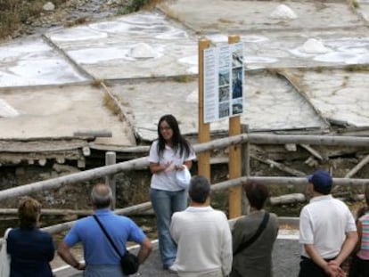Un grupo de visitantes atiende a las explicaciones de la guía en las salinas de Añana. 