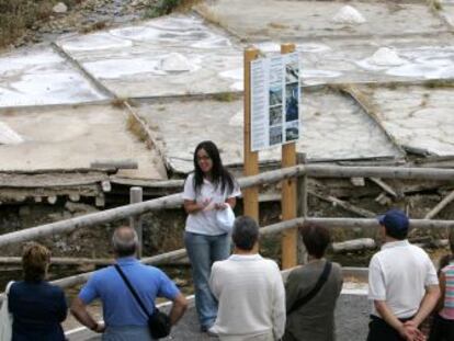 Un grupo de visitantes atiende a las explicaciones de la guía en las salinas de Añana. 