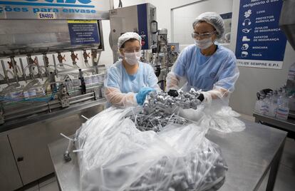 Dos mujeres trabajan en el laboratorio de una fábrica de alcohol en gel en Piracicaba, en Brasil.