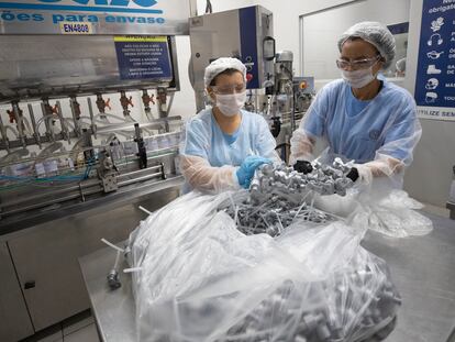 Dos mujeres trabajan en el laboratorio de una fábrica de alcohol en gel en Piracicaba, en Brasil.