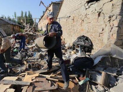 Tres hombres retiran escombros de sus casas tras un bombardeo en la regi&oacute;n de Donetsk.