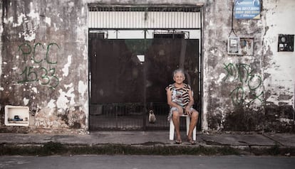 Moradora do Pirambu descansa ao lado de pichação do PCC.