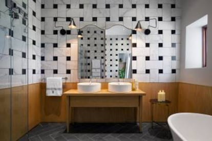 Las tradicionales rejillas de las sillas de Cape Dutch se replicaron en la disposición geométrica de los azulejos de los baños. |