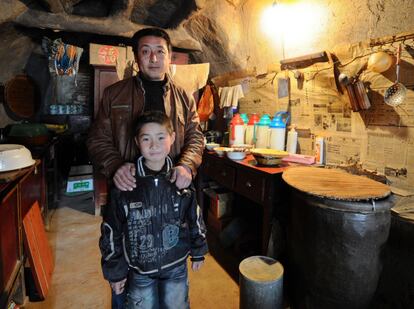 Feng Xianmig posa con su padre. Vive con sus abuelos en una de las cuevas que componen el pueblo de Tanda, y es uno de los 204 alumnos de la escuela, en la que el único ordenador que había murió por culpa de un virus que nadie ha sabido eliminar.