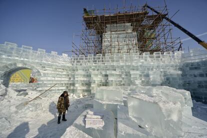 Uno de los 10.000 obreros que trabajan en el parque espera a la llegada de más bloques de hielo para continuar con la construcción de un fuerte al estilo tradicional chino.