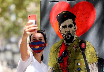 Una seguidora se hace una fotografía con el retrato de Leo Messi caracterizado como el Che Guevara.