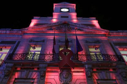 La sede de la Comunidad de Madrid, en la Puerta del Sol, iluminada de rojo por la celebración del Día Mundial del Sida, en recuerdo de las personas que han fallecido a consecuencia de la enfermedad. 