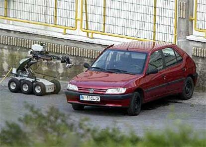 El coche cargado con la bomba trampa, junto al robot de los artificieros, que no pudo ser utilizado.