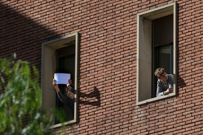 Dos jóvenes miran por la ventana de su habitación en el colegio mayor Penyafort de Barcelona, donde están en cuarentena por un brote de coronavirus.