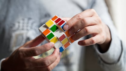 Un hombre juega con el rompecabezas cúbico inventado en 1974 por Ernö Rubik.