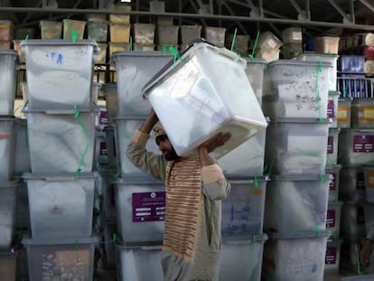Trabajadores de la Comisión Electoral Independiente trasladan las urnas a un depósito tras las elecciones parlamentarias, en Herat (Afganistán).