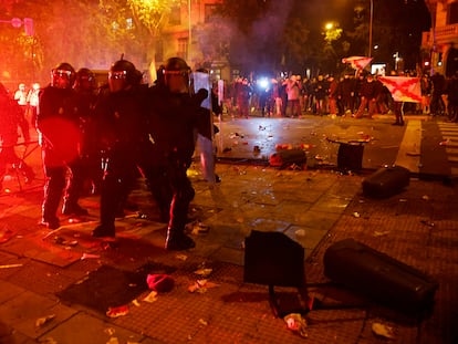 Agentes se agrupan al tiempo que manifestantes lanzan objetos contra ellos el martes.