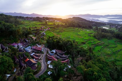 Amanecer sobre el espectacular paisaje de la zona de Batutumonga en Tana Toraja (Indonesia), carretera que pasa por un pueblo, arrozales, bosques y montañas.