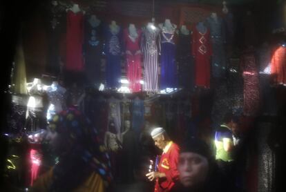 La vida diaria a través del 'niqab'. Tiendas del mercado Khan el-Khalili en El Cairo (Egipto). Los colores de los trajes que se venden en los puestos fundamentalmente turísiticos, quedan difuminados por el velo.