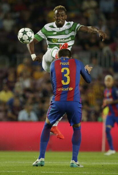 Moussa Dembele (a dalt) del Celtic salta davant de Gerard Piqué del Barcelona.