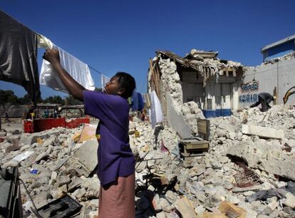 Mulher estende roupa entre os escombros do terremoto do Haiti, em 2010.